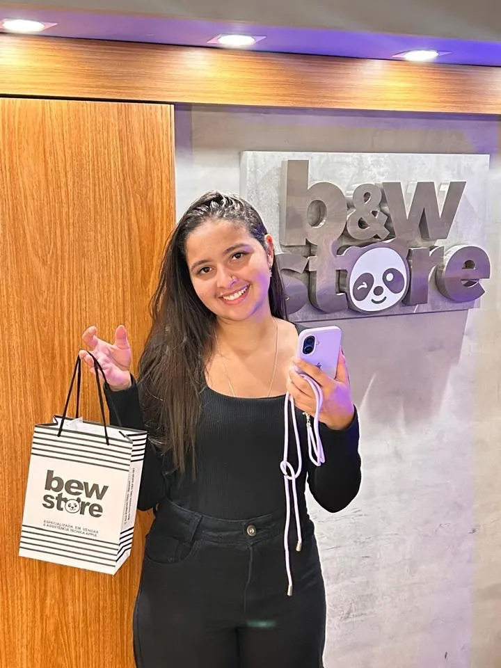 Cliente da B&W com a sacola da loja em frente ao logo